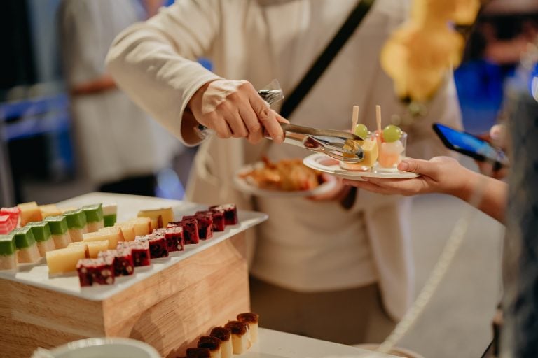 Guest being served desserts at a corporate buffet