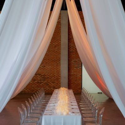 Draped event hall with exposed brick at The Lobby at EX8