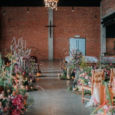 Floral wedding aisle with Edison-bulb chandelier at The Lobby at EX8